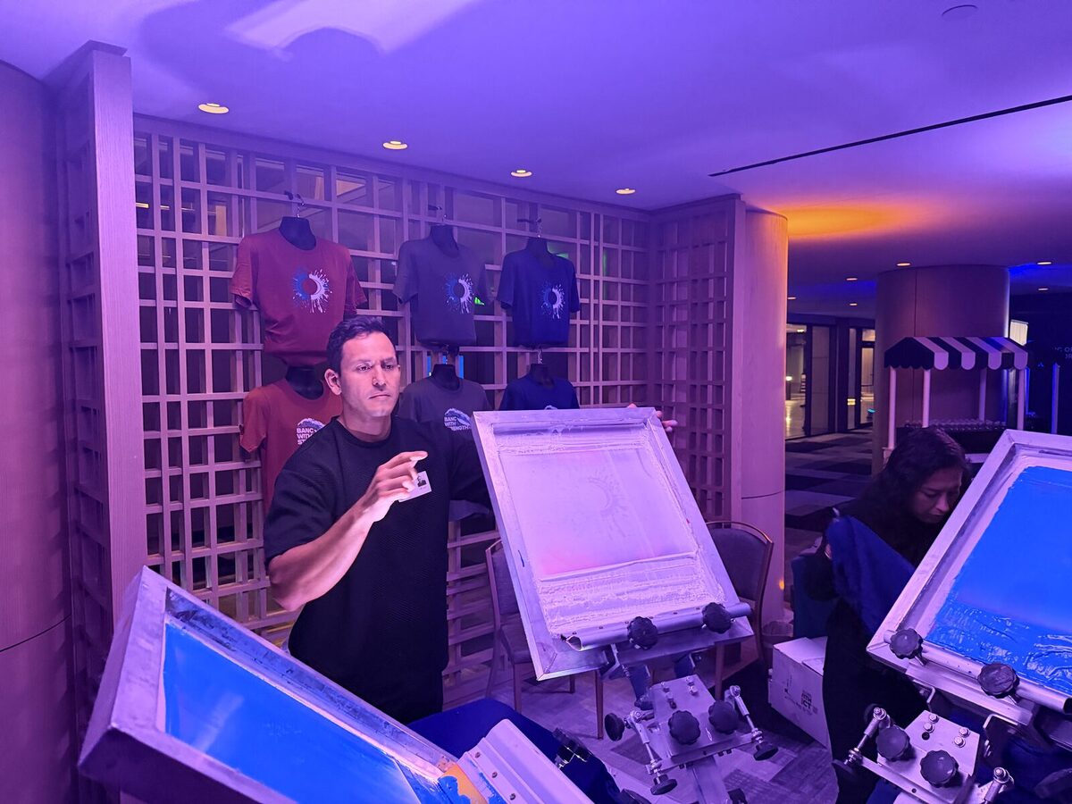 Hat bar setup alongside custom tees at a live printing event