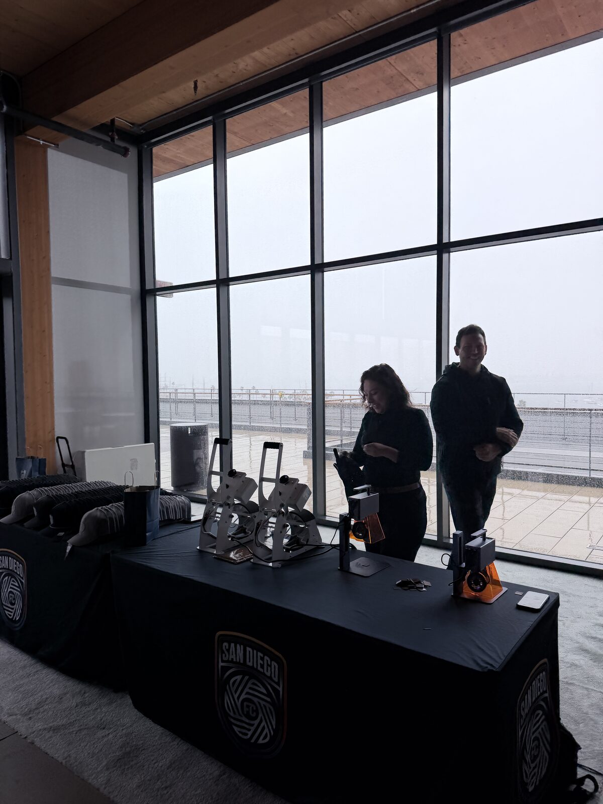 Staffed hat press station with an operator finishing a cap at an event