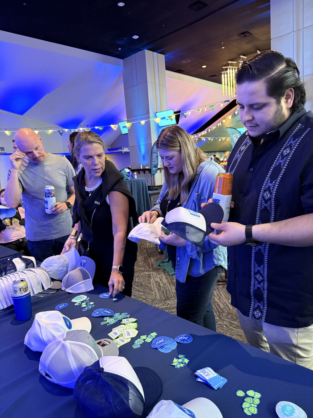 Professional event booth displaying branded caps and promotional apparel with a booth staff member and organized merchandising setup